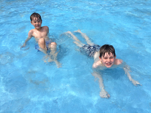男孩们在游泳池里游泳图片下载