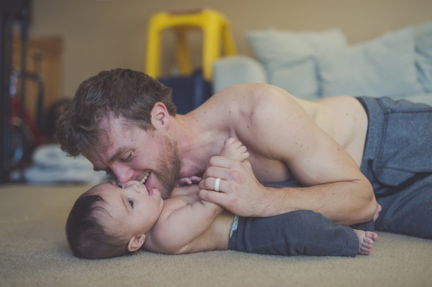 爸爸在地板上和他的婴儿扭打着图片下载
