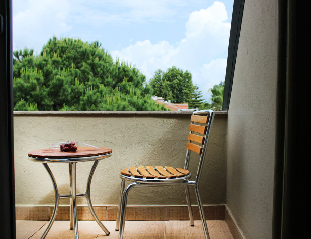阳台上的景色。阳台上的一张椅子和一张桌子，俯瞰着街道。娱乐的地方图片下载