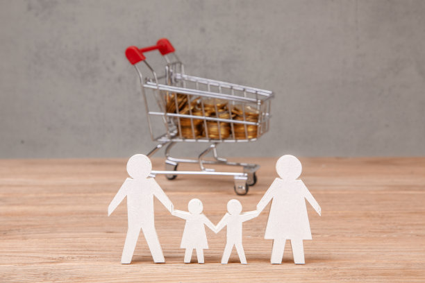 家庭预算。装满硬币和家庭标志的购物车图片下载