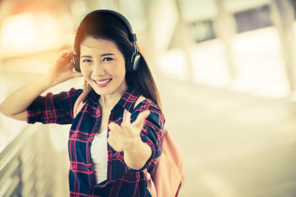 美丽幸福年轻的亚洲女孩在休闲服装独自旅行在火车站或机场与背包复古色调照片概念图片下载