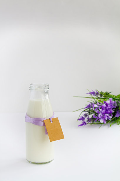 白色背景上的一瓶牛奶和鲜花图片下载