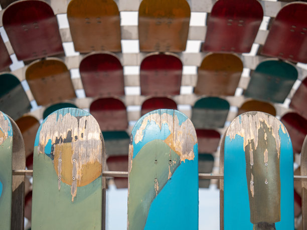 在一个阳光明媚的日子里，风化剥落的滑板安装在一根栏杆上图片下载