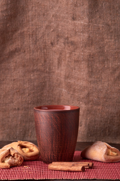 咬了一口农家干酪饼干。木制背景上的自制面包，里面塞满了白软干酪和黏土牛奶杯。宏观照片。有选择性的重点。图片下载