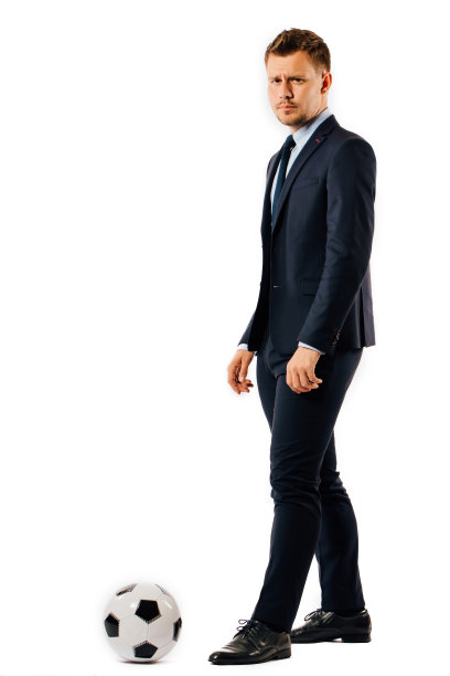 年轻英俊的商人经理踢一个足球在白色的背景孤立图片下载