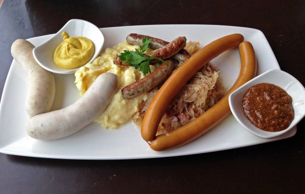 什锦香肠拼盘德国餐馆的什锦香肠拼盘，配有土豆泥、泡菜和芥末图片下载