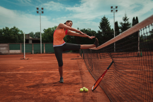在红土场上进行比赛的年轻网球运动员图片下载