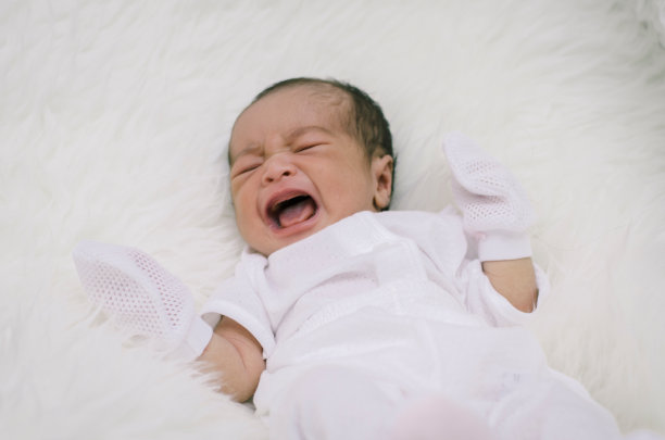 在床上睡觉时婴儿哭泣的高角度视图图片下载