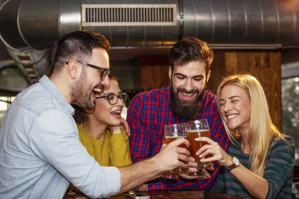 朋友们在当地酒吧里举杯互敬，面带微笑图片下载