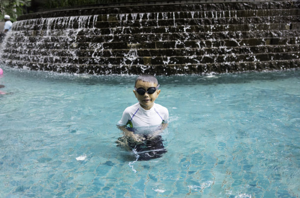 小男孩穿着泳衣在泳池里图片下载