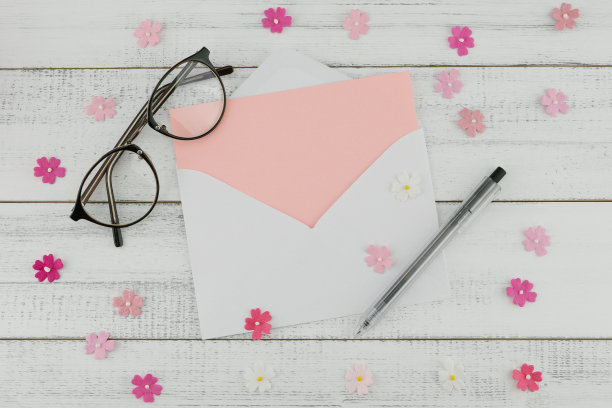 白色信封里的粉色空白卡片，钢笔和眼镜图片下载