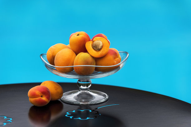 花园餐桌上的玻璃碗里新鲜杏的特写图片下载