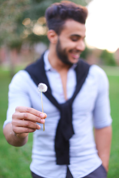 西班牙男子吹蒲公英的模糊照片图片下载