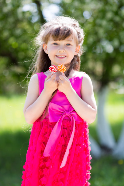 穿着红色连衣裙，手里拿着糖果的女孩图片下载