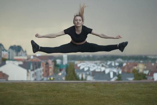年轻的白人女孩表演麻绳跳过背景城市景观图片下载