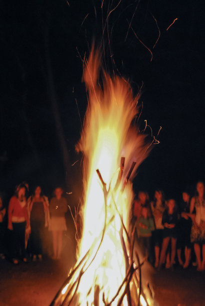 人们在晚上看篝火的垂直照片，篝火图片下载