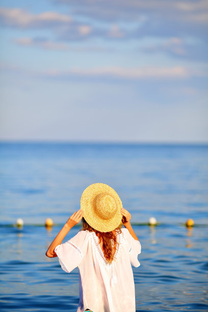 戴着帽子穿着白色衣服的女人在海里图片下载