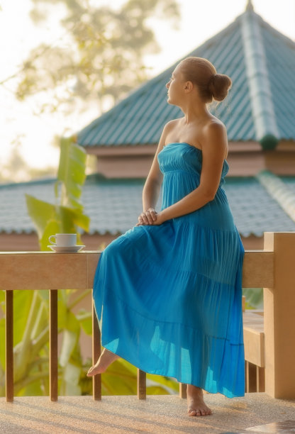 年轻女子在早晨的露台上喝咖啡图片下载