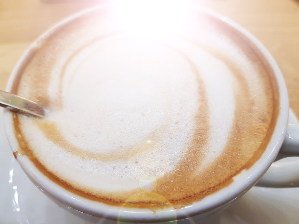 木桌上放着一杯卡布奇诺咖啡，俯视图图片下载