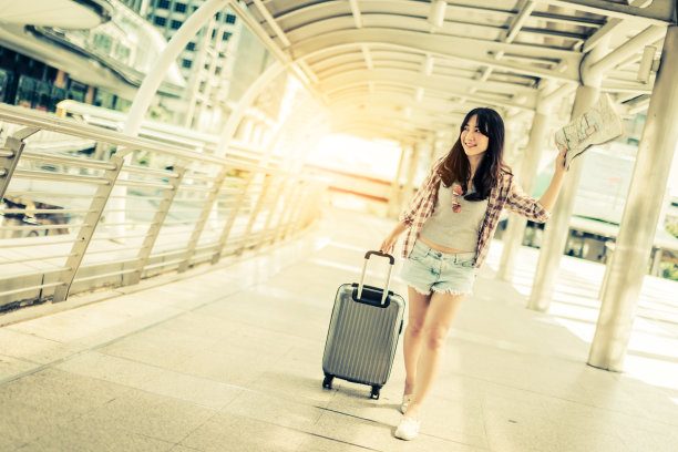 美丽幸福年轻的亚洲女孩在休闲服装独自旅行在火车站或机场与背包复古色调照片概念图片下载