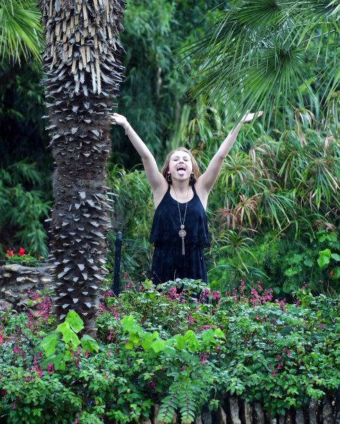 年轻女孩摆姿势的高中毕业照片与帽子和长袍图片下载