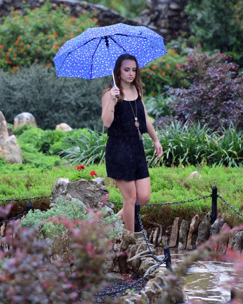 年轻女孩摆姿势的高中毕业照片与帽子和长袍图片下载