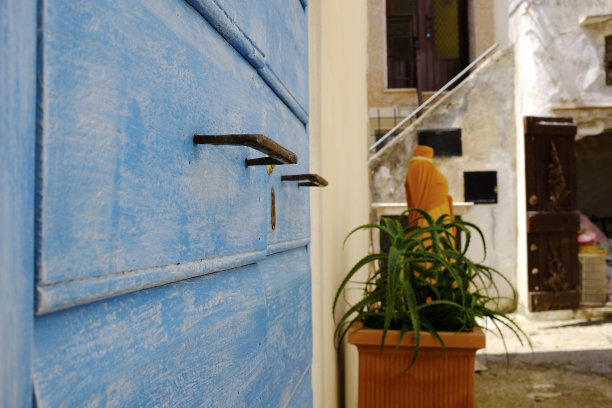 在圣费利斯Circeo(海边)，意大利拉齐奥市的古老和历史悠久的蓝色木材门-在背景出售的衣服。图片下载