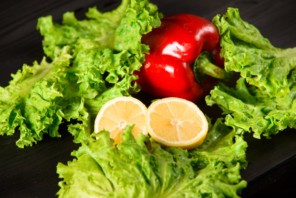 食物照片柠檬，纸和绿色的叶子在黑暗的木制背景图片下载