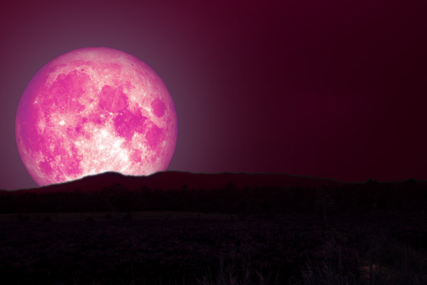 粉红色的满月越过乡间的剪影山图片下载