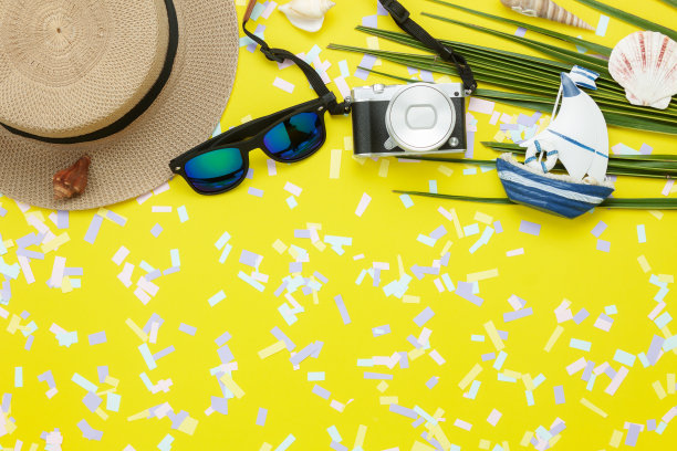 表顶视图航拍图片项目旅游夏季假期背景概念。平铺旅行必备配件，适合去海滩旅行。时尚太阳镜，相机和帽子上的绿色椰子叶。图片下载