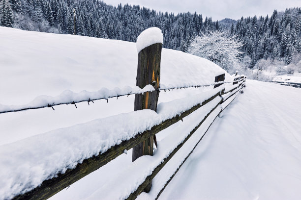 冰雪覆盖的栅栏在冬天的路上徒步行走。图片下载