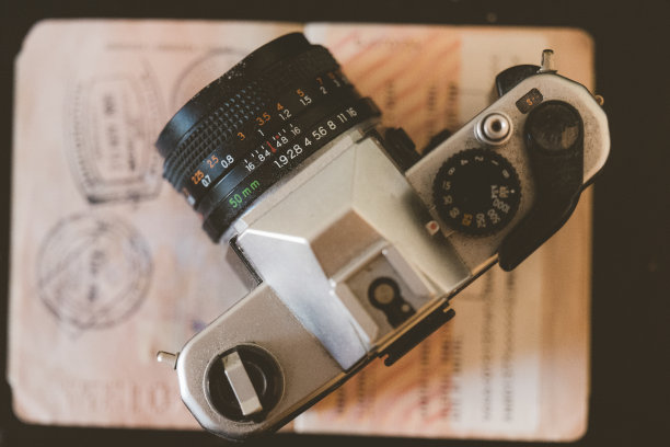 一台老式胶卷相机和一张盖了章的护照图片下载