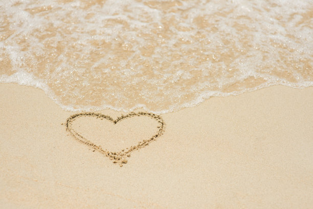 沙滩上的一颗心象征着海浪。图片下载