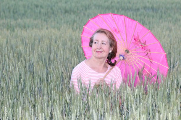 成熟的女人拿着一把粉红色的伞图片下载