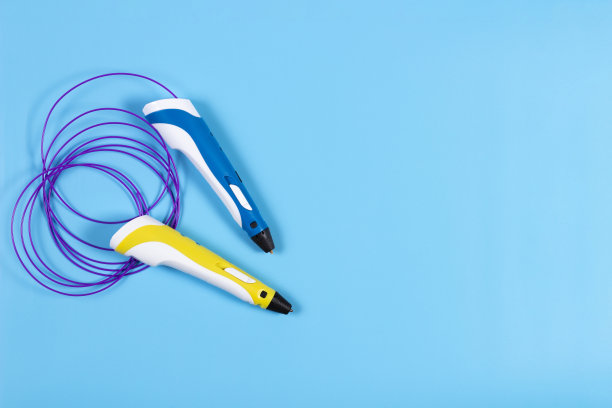 3d笔与彩色塑料丝在蓝色背景图片下载