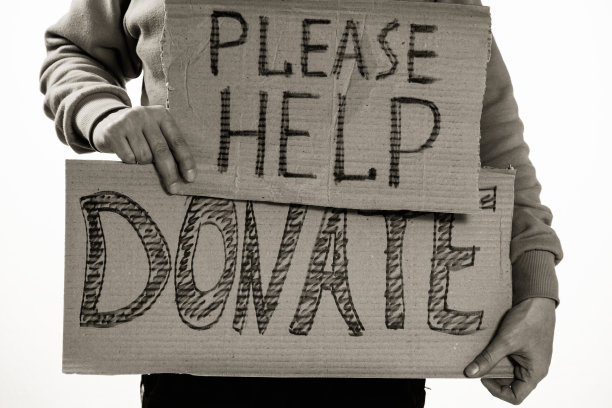无家可归的穷人举着写着“请帮助，捐赠”的纸板图片下载