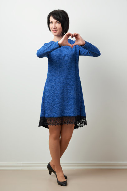 一个穿着蓝色裙子的女人，展示了心脏的形状图片下载