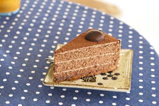 美味的巧克力蛋糕盘子上的古董桌子与复制空间。图片下载