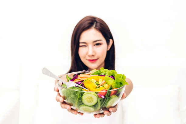 快乐女人展示健康沙拉，健康饮食理念图片下载
