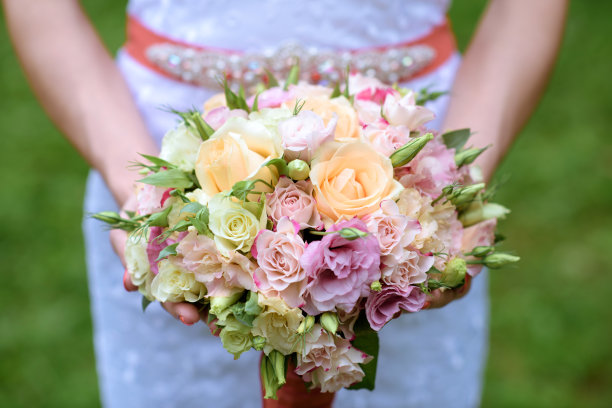 美丽的新娘捧着婚礼上五颜六色的花束图片下载