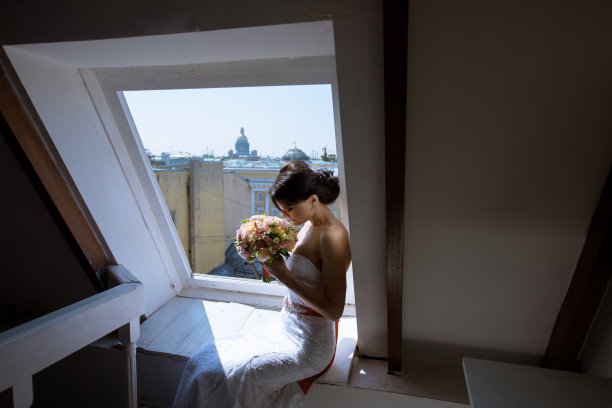 美丽的新娘在室内新娘礼服与花束和蕾丝面纱图片下载