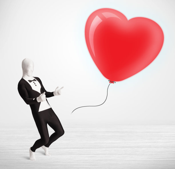 穿着变形紧身衣的帅哥看着一个气球形状的心脏图片下载