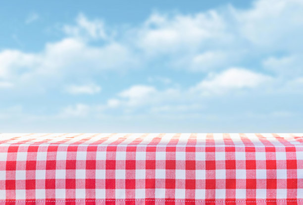 红色的桌布在一个笼子里堆着，背景是天空和云彩图片下载