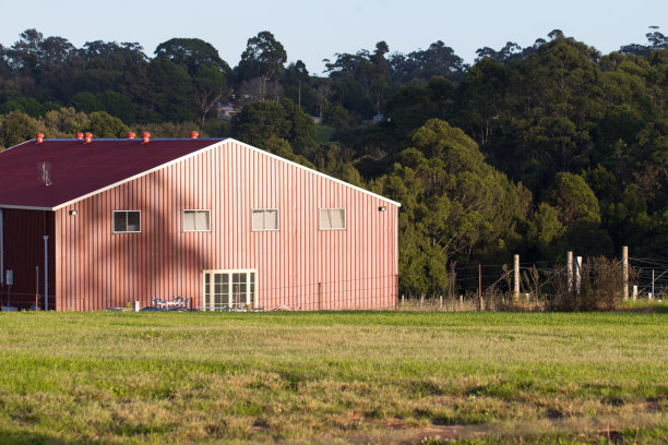 红木材谷仓房子在农场绿色的草地围场图片下载