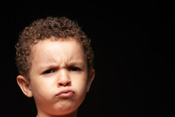 一个巴西男孩站在黑色背景前图片下载