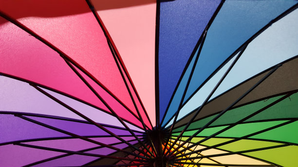 在蓝天的背景上打开七彩彩虹伞图片下载