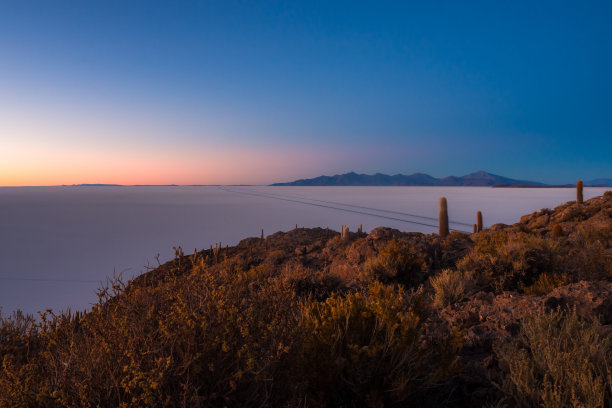 景观在乌尤尼盐田日出期间，有公路和高山。来自玻利维亚Inka Huasi岛的照片图片下载