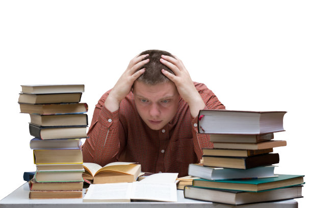 一个困惑的家伙坐在一张桌子旁，桌上有一堆书，在白色的背景上孤立地放着图片下载