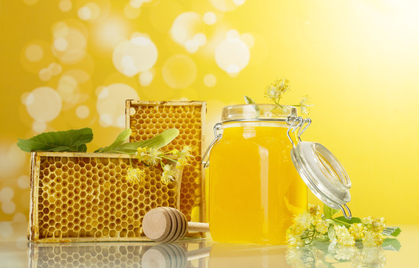 蜂木框架，蜂蜜和纺锤罐在黄色的背景图片下载