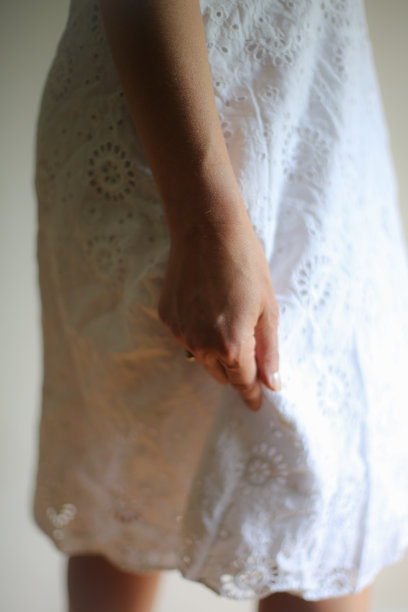 腰下的肖像，一个白人妇女穿着白色网眼连衣裙室内图片下载